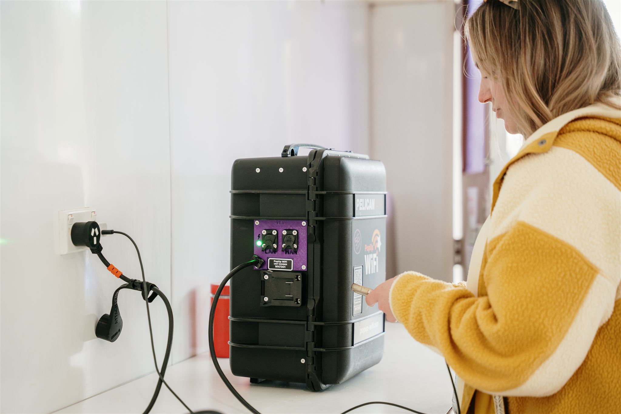 Staff member scanning QR code on PopUp WiFi bonded internet for event rental unit inside the festival production office.